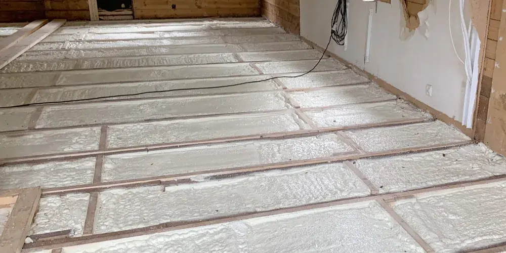 Bjälklag isolerat med RadonFoam mellan reglar — sömlös sprutad barriär